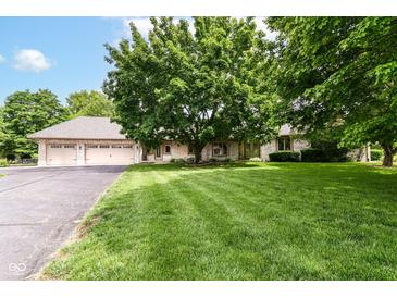 Charming brick home featuring a well-manicured lawn and mature trees enhancing its curb appeal at 7220 Normandy Way, Indianapolis, IN 46278