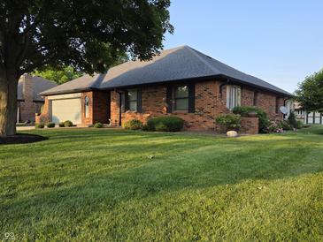 Charming brick home featuring an attached garage, mature trees, and a well-maintained lawn at 1201 Briarwood Dr, Brownsburg, IN 46112