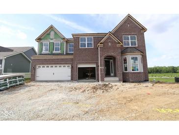 New two-story brick home featuring an attached two-car garage and unfinished landscaping at 12338 French Cattle Way, Noblesville, IN 46060