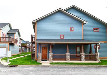 Charming blue two-story home with inviting porch and stone accents. Houses in the distance at 1635 N College Ave # 4, Indianapolis, IN 46202