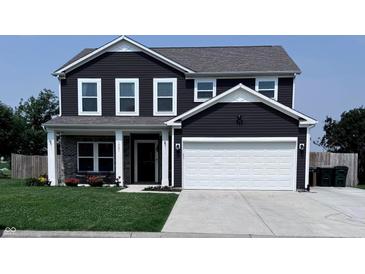 Charming two-story home with a well-manicured lawn, a covered porch, and a two-car garage at 1721 N Kaleigh Ln, Greensburg, IN 47240
