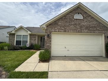 Charming brick home with a well-manicured lawn and two car garage at 2302 Rolling Oak Dr, Indianapolis, IN 46214