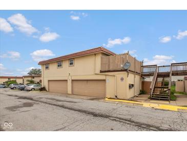 Two-story home with a terra cotta roof, two garage doors, and a stairway leading to an upper deck at 2766 Del Prado Dr # 6, Indianapolis, IN 46227