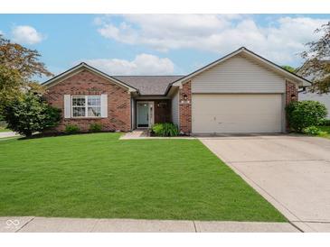 Charming brick home features a manicured lawn, attached garage, and inviting light blue front door at 293 E Quail Wood Ln, Westfield, IN 46074