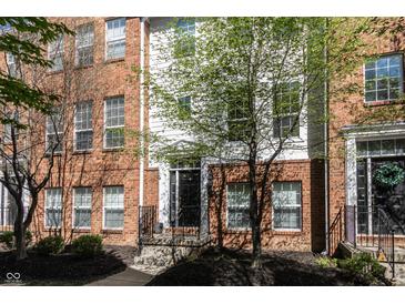 Charming brick townhome featuring a black front door and lush green tree in front at 420 Beverly Ct, Carmel, IN 46032
