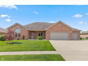 Charming brick home with a manicured lawn, attached garage and beautiful landscaping at 5229 Imperial Dr, Columbus, IN 47203