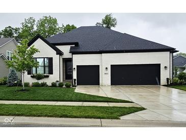Charming home boasts a painted brick exterior, black trim, and a two-car garage at 5686 Ellie Ct, Noblesville, IN 46062