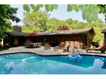 Inviting backyard oasis with pool, brick patio, and ample seating for outdoor entertaining at 6519 Creekside Ln, Indianapolis, IN 46220