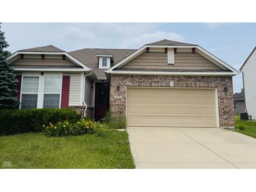 Charming home featuring a brick facade, tan siding, and a two-car garage at 8176 Crumwell Dr, Avon, IN 46123