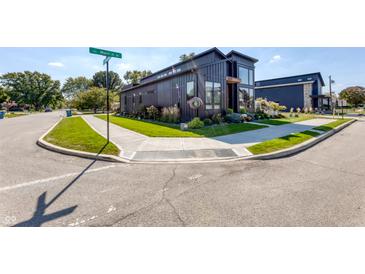 Modern black home on a corner lot features professional landscaping and a sidewalk at 8695 Morgan Dr, Fishers, IN 46038