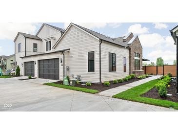 Modern two-story home showcasing a two-car garage, neutral siding, and manicured landscaping at 1677 Solebar Way, Westfield, IN 46074