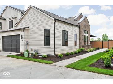 Charming home featuring sleek black window frames, a dark garage door, and a well-manicured lawn at 1677 Solebar Way, Westfield, IN 46074