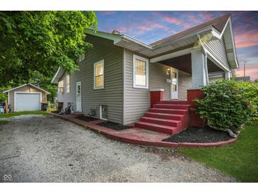 Charming home with red steps, landscaped yard, and detached garage at 1915 Albany St, Beech Grove, IN 46107