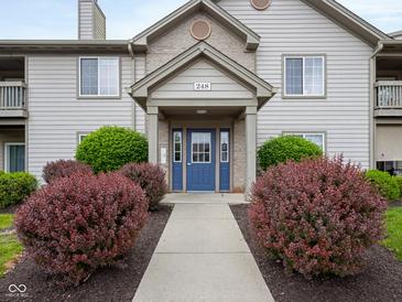 Inviting condominium entrance featuring well-maintained landscaping and a charming blue door at 248 Legends Creek Pl # 207, Indianapolis, IN 46229