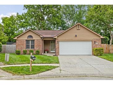 Charming single-story home featuring a manicured lawn, brick accents, and an attached two-car garage at 3304 Fox Orchard Cir, Indianapolis, IN 46214