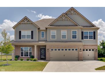 Charming two-story home showcasing a blend of brick and gray siding, complemented by a well-manicured lawn at 4163 Ironclad Dr, Bargersville, IN 46106