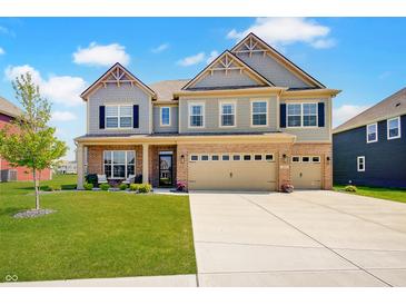 Beautiful two-story home with brick and siding exterior, well-manicured lawn, and a two-car garage on a sunny day at 4163 Ironclad Dr, Bargersville, IN 46106