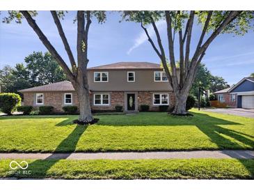 Charming two-story home with brick and siding, mature trees and a well-manicured lawn at 567 Hawthorne Dr, Carmel, IN 46033
