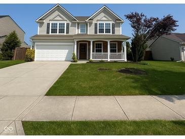 Charming two-story home boasts a well-manicured lawn, attached two car garage, and welcoming front porch at 5683 James Blair Dr, Indianapolis, IN 46234