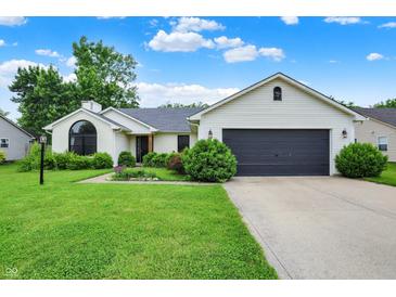 Charming ranch home featuring a well-manicured lawn, a gray garage door, and manicured shrubs at 572 Quail Ridge Dr, Westfield, IN 46074