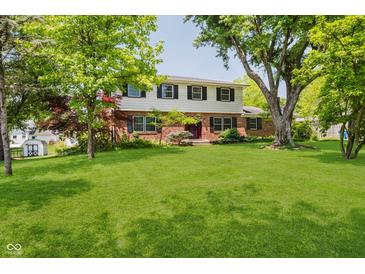 Charming two-story home featuring a manicured lawn and mature trees at 6146 Rucker Rd, Indianapolis, IN 46220