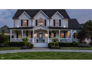 Beautiful two story home with a charming front porch, white siding and dark shutters, and a well manicured front yard at 6685 Chapel Xing, Zionsville, IN 46077