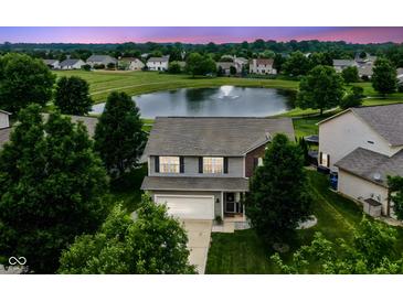 An aerial view of a beautiful home in a peaceful neighborhood, complete with a scenic pond and mature trees at 7214 Morello Ln, Noblesville, IN 46062