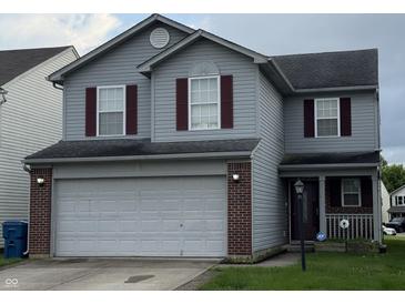 Traditional two-story home featuring a two-car garage, red shutters and vinyl siding at 8056 Maple Stream Blvd, Indianapolis, IN 46217