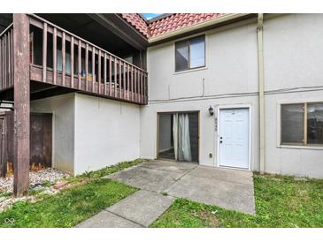 Exterior of home featuring a balcony, white stucco, tile roof, front door, and concrete patio at 8545 La Corrida Ct, Indianapolis, IN 46227