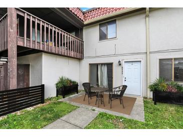 Charming townhouse with a front patio, wooden balcony, and well-maintained landscaping at 8545 La Corrida Ct, Indianapolis, IN 46227
