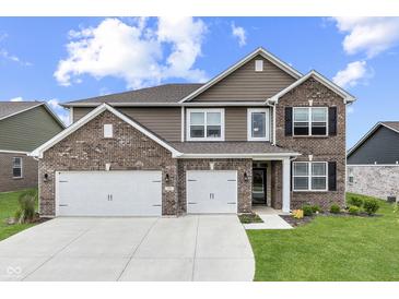 Beautiful two-story home featuring a brick and siding facade, a three-car garage, and a well-manicured lawn at 928 Ridge Rock Ln, Bargersville, IN 46106