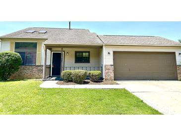 Charming single-Gathering home with a well-maintained lawn and attached garage, situated on a sunny day at 10922 Snowdrop Way, Indianapolis, IN 46235