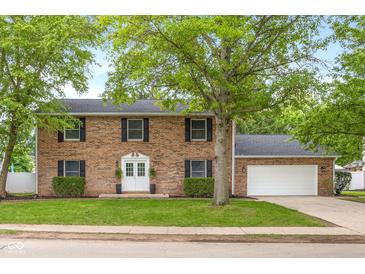 Charming two-story brick home with black shutters, white door and a well-manicured lawn at 1127 Junco Dr, Columbus, IN 47203