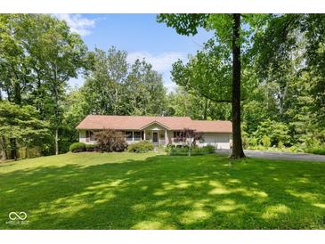 Charming single-story home with a manicured front yard, mature trees, and an attached garage, all bathed in sunlight at 1350 Inverness Farms Rd, Martinsville, IN 46151