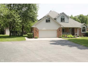 Two story home featuring a brick and vinyl exterior, two car garage, and front porch at 1739 S County Road 450 E, Avon, IN 46123