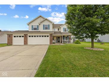 Charming two-story home with a three-car garage and a well-manicured lawn featuring a quaint front porch at 2580 Bluewood Way, Plainfield, IN 46168