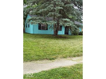 Charming single-story home with vibrant blue siding and a well-maintained front yard, shaded by a mature tree at 5938 Price Ln, Indianapolis, IN 46254