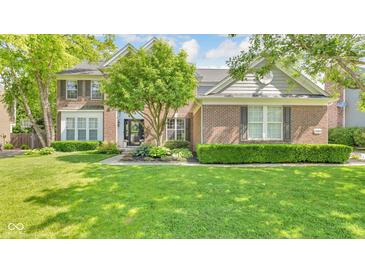 Traditional brick home featuring manicured lawn, mature landscaping, and charming curb appeal at 13304 Landwood Dr, Fishers, IN 46037