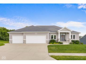 Charming single-Gathering home featuring a three-car garage and a beautifully landscaped front yard at 1497 Maple Ridge Ct, Columbus, IN 47201