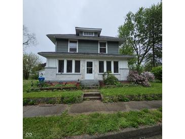 Charming two-story home with white and green exterior and a small yard at 1617 Blaine Ave, Terre Haute, IN 47804