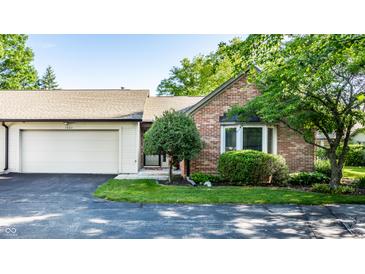 Charming brick home with attached garage and well-manicured front yard landscaping at 1663 Cloister Dr, Indianapolis, IN 46260