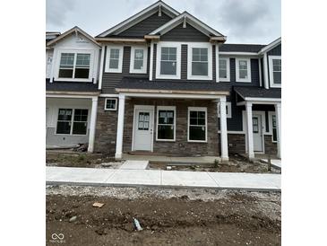 New construction townhome with stone facade, covered entry, and white trimmed windows at 19541 Grassy Branch Rd, Westfield, IN 46074
