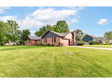 Charming brick home with a well-manicured lawn and mature trees on a sunny day at 206 Banbury Rd, Noblesville, IN 46062