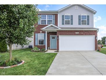 Charming two-story home with brick facade, blue shutters, landscaped yard, and a two-car garage at 2101 Shadow Fox Dr, Columbus, IN 47201