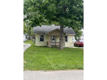 A charming one-story home with a front porch framed by a mature tree at 4521 Vernon Ave, Indianapolis, IN 46226