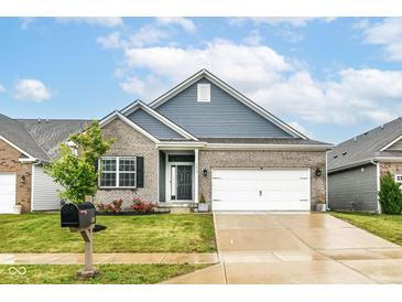 Charming single-Gathering home with a gray brick facade, blue siding and a well-manicured lawn and a two car garage at 5439 Maywood Dr, Whitestown, IN 46075