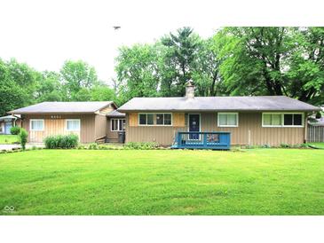 Charming single-story home with a well-manicured lawn and a cozy blue front porch at 6601 Twin Brooks Dr, Indianapolis, IN 46227