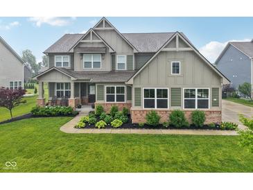 Charming two-story home featuring a beautifully landscaped yard and a welcoming front porch at 8165 Oakley Ter, Zionsville, IN 46077