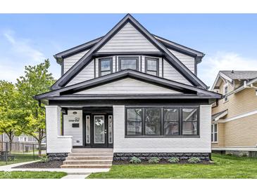 Charming two-story home with white and black accents, landscaped yard, and inviting curb appeal at 911 Eastern Ave, Indianapolis, IN 46201