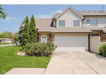 Charming townhome featuring an attached two-car garage and manicured lawn at 9406 Avon Strand # Apt A, Avon, IN 46123